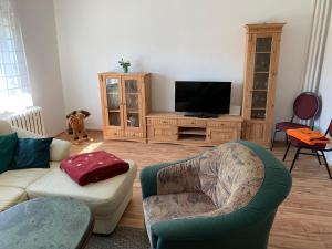 a living room with a couch and a flat screen tv at Ferienhäuser Wede in Ueckeritz