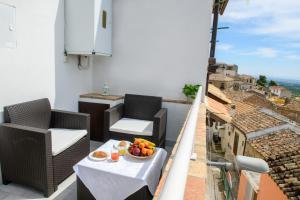 a balcony with chairs and a bowl of fruit on a table at Terrazzo sullo Ionio in Nova Siri