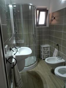 ein Bad mit einem Waschbecken, einer Dusche und einem WC in der Unterkunft A un passo dal mare Budoni - Matta e Peru in Tanaunella