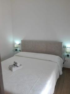 ein Schlafzimmer mit einem großen weißen Bett mit zwei Lampen in der Unterkunft A un passo dal mare Budoni - Matta e Peru in Tanaunella