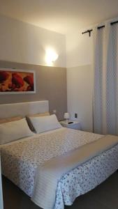 a bedroom with a large bed with white sheets at Welcome Holiday House in Polignano a Mare