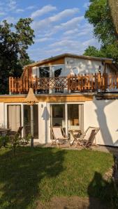 ein Haus mit einer Terrasse und Stühlen im Hof in der Unterkunft Neuenkirchen Moritzhagen in Neuenkirchen