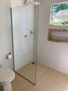 a bathroom with a glass shower with a toilet at Suite Confortavel em Chapada dos Guimaraes in Chapada dos Guimarães
