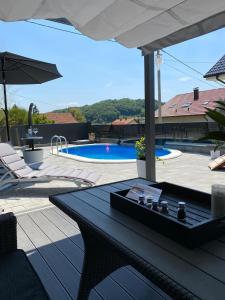 a patio with a table and chairs and a pool at AQUA-TUHELJ- SKY in Tuheljske Toplice