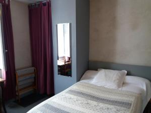 a small bedroom with a bed and a mirror at H&ocirc;tel Les Templiers in Luz-Saint-Sauveur