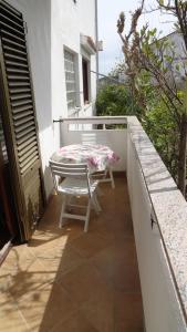 a table and a chair on a balcony with a table at Studio Apartment in Palit with Balcony, Air Conditioning, Wi-Fi (4603-4) in Mundanije