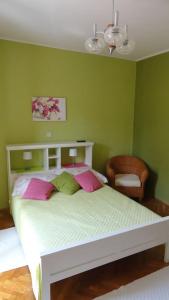 a bedroom with a bed with pink and green walls at Studio Apartment in Palit with Balcony, Air Conditioning, Wi-Fi (4603-4) in Mundanije