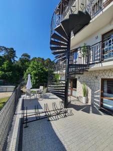 a patio with two chairs and a table and a staircase at Villa Lordis in Krynica Morska