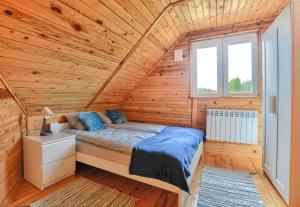 a bedroom with a bed in a wooden cabin at W dolinie Sanu in Lesko