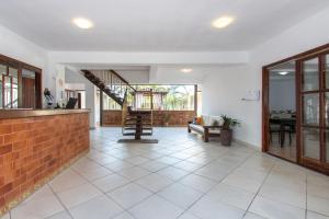 a living room with a brick wall and a staircase at Pousada Casuarina Ferradura in Búzios