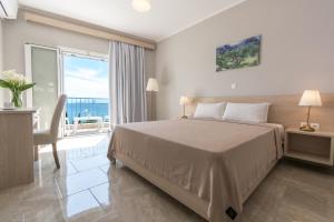 a bedroom with a large bed and a balcony at Corfu Aquamarine in Nótos