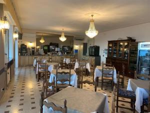 ein Restaurant mit weißen Tischen und Stühlen und Lichtern in der Unterkunft Hotel Svizzera in Arma di Taggia