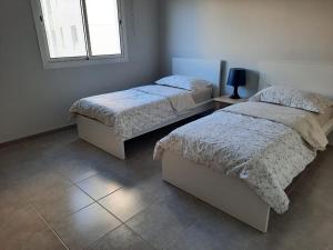 a bedroom with two beds and a window at سن رايز in King Abdullah Economic City