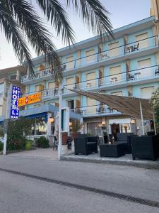 a hotel with a palm tree in front of it at Hotel Svizzera in Arma di Taggia