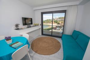a living room with a table and a blue couch at Mert Otel in Çeşme