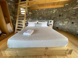 a bedroom with a bed in a stone wall at Windmills Village Amarynthos in Amarinthos