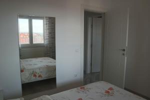 a bedroom with two beds and a mirror at Apartman Lilly in Modriča