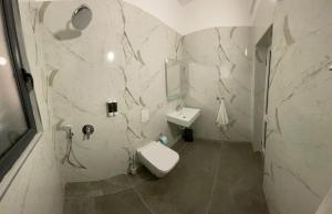 a white bathroom with a toilet and a sink at Karaburun Sunset Beach in Orikum +57 photos