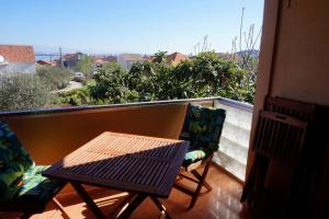 a table and chairs on a balcony with a view at Apartments Ivanković in Preko