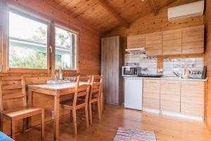 a kitchen with a table and chairs in a cabin at Puszczykowo in Stegna