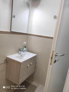 bagno con lavandino e specchio di Residenza Marvasi 10 a Caserta