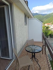patio con mesa y sillas en el balcón en Lastva Holliday Rooms, en Budva