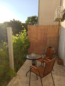a patio with two chairs and a table and a table and chairs at Lastva Holliday Rooms in Budva