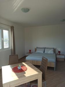 1 dormitorio con cama, mesa y comedor en Lastva Holliday Rooms, en Budva