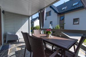 a wooden table and chairs on a patio at Domki Jelonek - Całoroczne, ogrzewane, klimatyzowane in Władysławowo