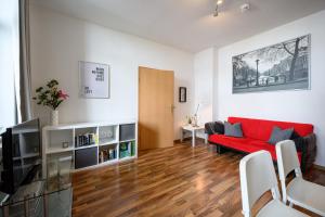 - un salon avec un canapé rouge et une table dans l'établissement Helle Wohnung in Sudenburg mit Balkon - WLAN, 4 Schlafplätze, à Magdebourg