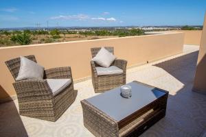 2 Stühle und ein Couchtisch auf dem Balkon in der Unterkunft Villa Ribeiro By Keys to Algarve in Armação de Pêra