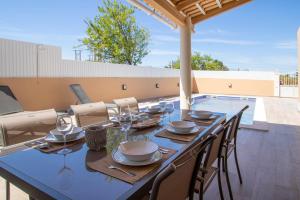 ein Esstisch und Stühle auf einer Terrasse in der Unterkunft Villa Ribeiro By Keys to Algarve in Armação de Pêra