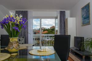 a living room with a table with a vase of flowers at Apartments Mijo in Trogir