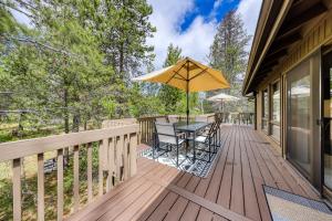 a deck with a table and chairs and an umbrella at 6 Red Cedar in Sunriver