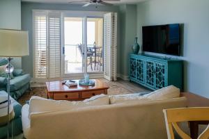 a living room with a couch and a tv at Beach Colony of Perdido West in Perdido Key