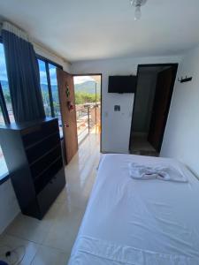 een slaapkamer met een bed en uitzicht op de oceaan bij Hotel Policarpa in Guaduas