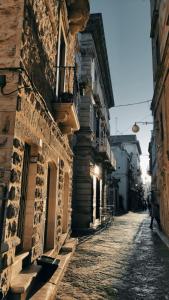 uma rua vazia num beco entre dois edifícios em B&B La Campanella em Putignano