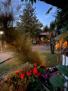 un jardín con flores rojas y moradas en un patio en B&B VILLA LUPIDI, en Corridonia