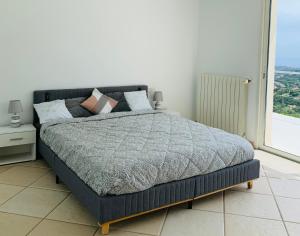 a bedroom with a bed and a large window at Maison avec vue panoramique in Cavalaire-sur-Mer