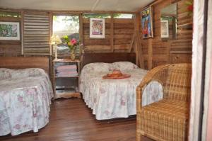 1 dormitorio con 2 camas, mesa y silla en Secret Cabins at Firefly Beach Cottage, en Negril