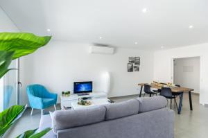 een woonkamer met een bank en een tafel bij Terraços Do Mar - Rooftop Pool with Sea View in Nazaré