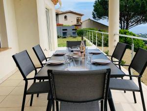 a black table and chairs on a patio at Maison avec vue panoramique in Cavalaire-sur-Mer