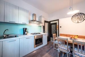 a kitchen with white cabinets and a table with a dining room at -Antermoia- Appartament Canazei Center in Canazei +24 photos