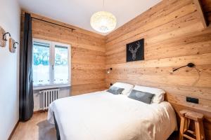 a bedroom with a bed in a wooden wall at -Antermoia- Appartament Canazei Center in Canazei