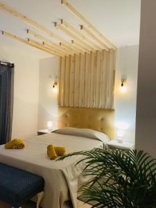 - une chambre avec un grand lit et 2 oreillers jaunes dans l'établissement Travellers Guesthouse, à Lagos