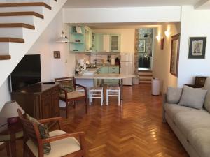 Il comprend un salon et une cuisine avec un canapé et une table. dans l'établissement Apartments Villa Mila, à Cavtat