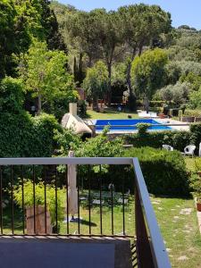 a balcony with a gate with a view of a garden at Navarro Hill Resort in Porto Santo Stefano