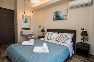 1 dormitorio con 1 cama grande y toallas. en La Torre, brand New (2021) Modern Apt in Alikanas, en Alikanas