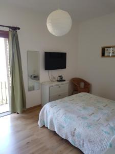 a bedroom with a bed and a flat screen tv at Navarro Hill Resort in Porto Santo Stefano