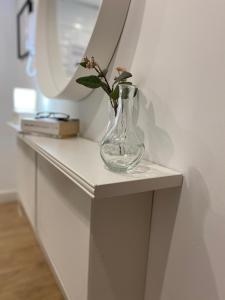 wazon na stole z kwiatem w obiekcie Apartamento Logroño Parlamento w mieście Logroño